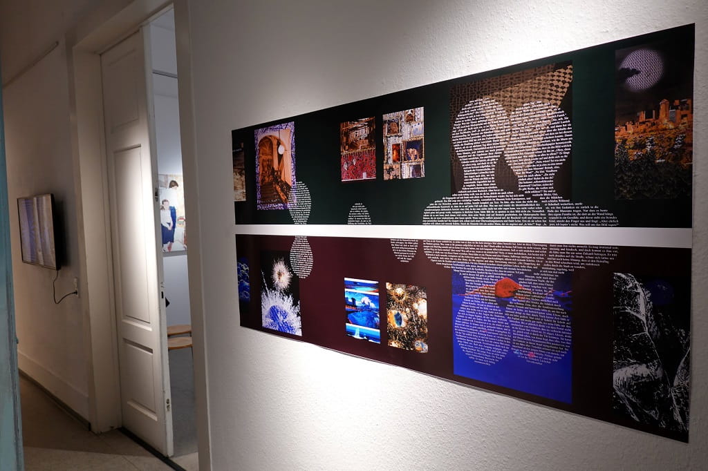 Lange, horizontale Wandarbeit in einer Galerie: Zwei übereinander angeordnete Bildstreifen kombinieren Fotografien, Textflächen und grafische Elemente; links öffnet sich ein Türdurchgang in einen weiteren Ausstellungsraum.